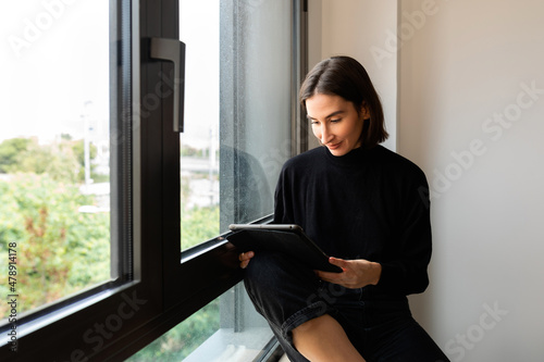 woman with tablet at the window photo