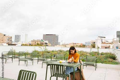 Woman working while having lunch on rooftop