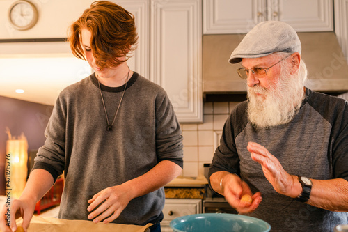 Grandson and pastry chef grandfather making biscuits photo