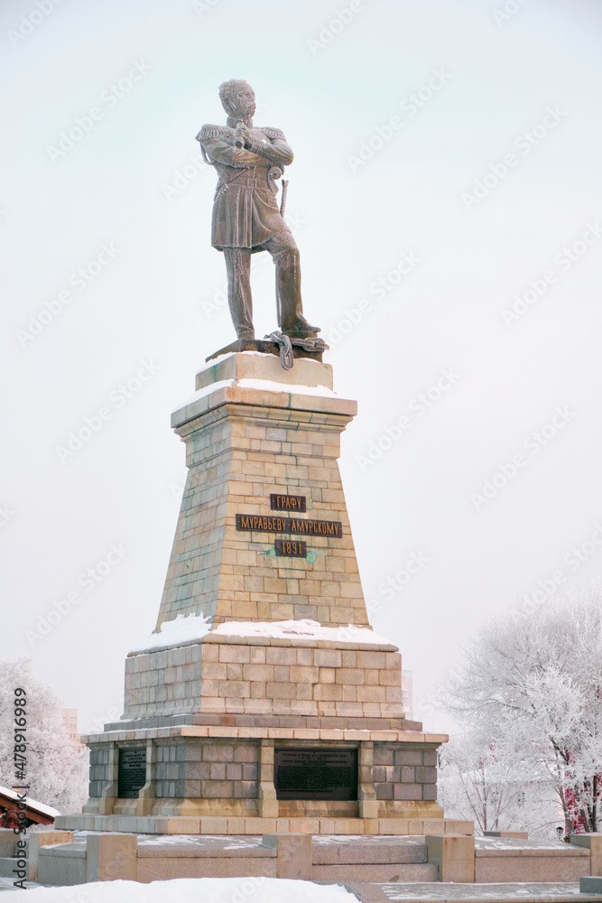 Obraz premium Monument to General Governor-General of Eastern Siberia Nikolai Nikolaevich Muravyov-Amursky in Khabarovsk in the morning at sunrise. There are trees in the snow all around.