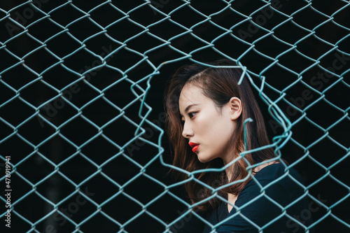 Woman profile portrait behind the mesh wire