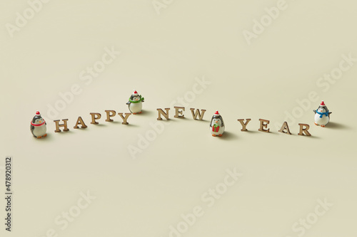 Happy new year message with penguins statuettes