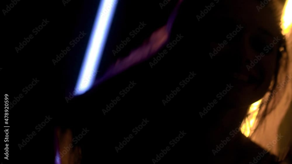 Caucasian girl dancing and having fun with neon and flash lights. Backlit silhouette beautiful dancer. Caucasian girl dancing and having fun with neon and flash lights. Backlit silhouette beautiful dancer.