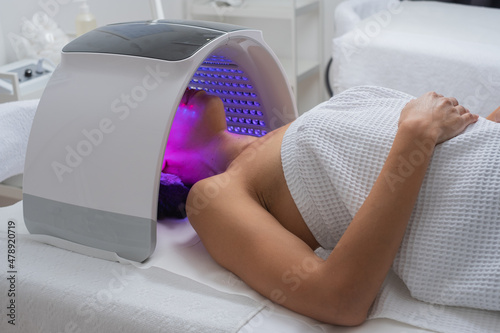Woman Under A LED Light Facial Therapy Lamp photo