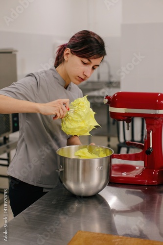 Baker checking consistence of cream 