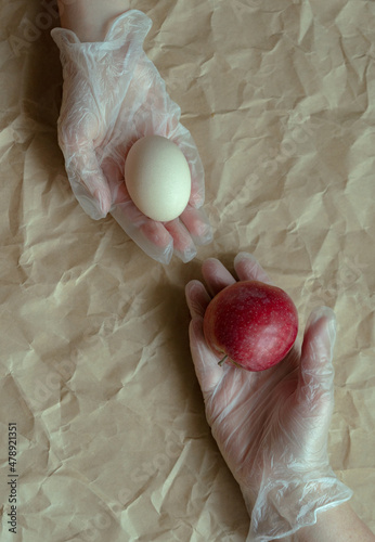 Conceptual still life, hands, egg, apple. photo