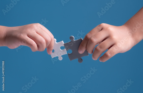 Teamwork and solution concept,Kids hands holding jigsaw