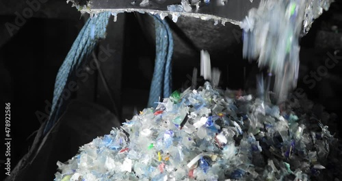 Plastic shredder. Recycling. Close-up of waste shredding process. Fraction. A bag full of shredded plastic. Environmental protection concept.