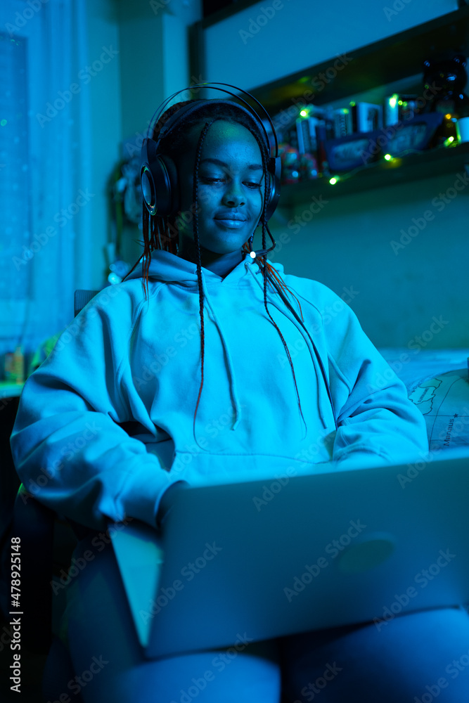 Teenage Black Gamer Playing In Her Bedroom At Night. Teenage Black Gamer Playing In Her Bedroom At Night.