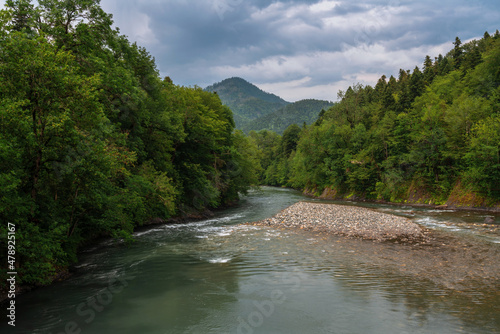 View of the Belaya River canyon on the territory of the Caucasian Biosphere Reserve on the Guzeripl cordon on a sunny summer day with clouds, Guzeripl, Republic of Adygea, Russia photo