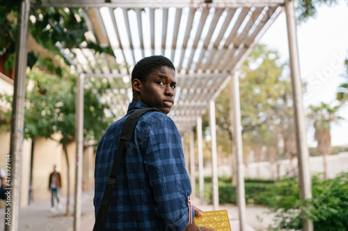 Serious student with book in park