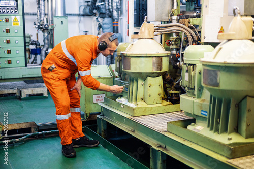 engineer in engine room checks work separator photo