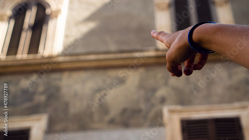 Hand pointing at a beautiful architecture house in Rome  photo