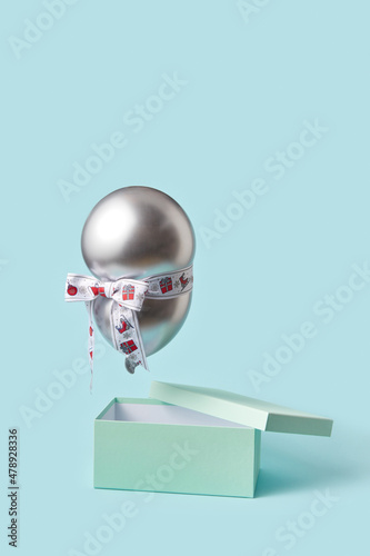 Balloon with ribbon flying over box photo