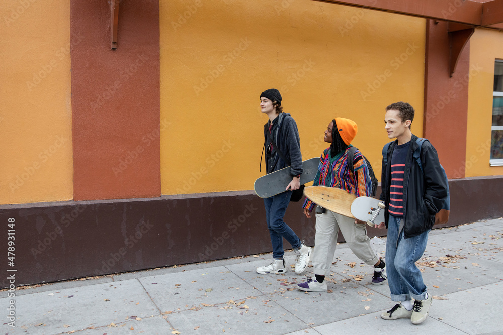Three Stylish Young Adults Walk Downtown Three Stylish Young Adults Walk Downtown