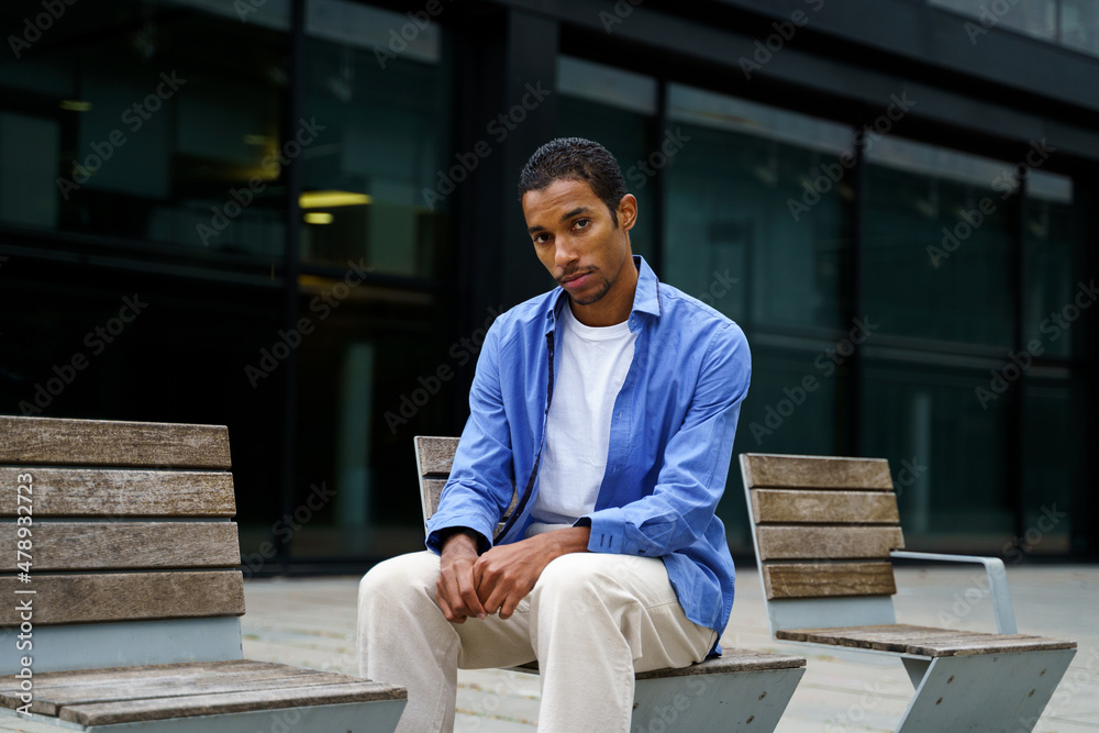 Portrait of Stylish man sitting on street bench Portrait of Stylish man sitting on street bench
