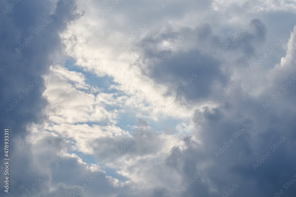 Cloudy sky background with sunlight through clouds