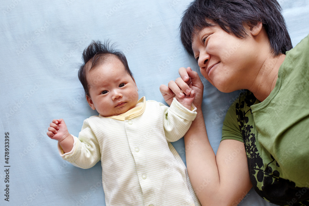 Closeup of newborn Asian baby and mom Closeup of newborn Asian baby and mom