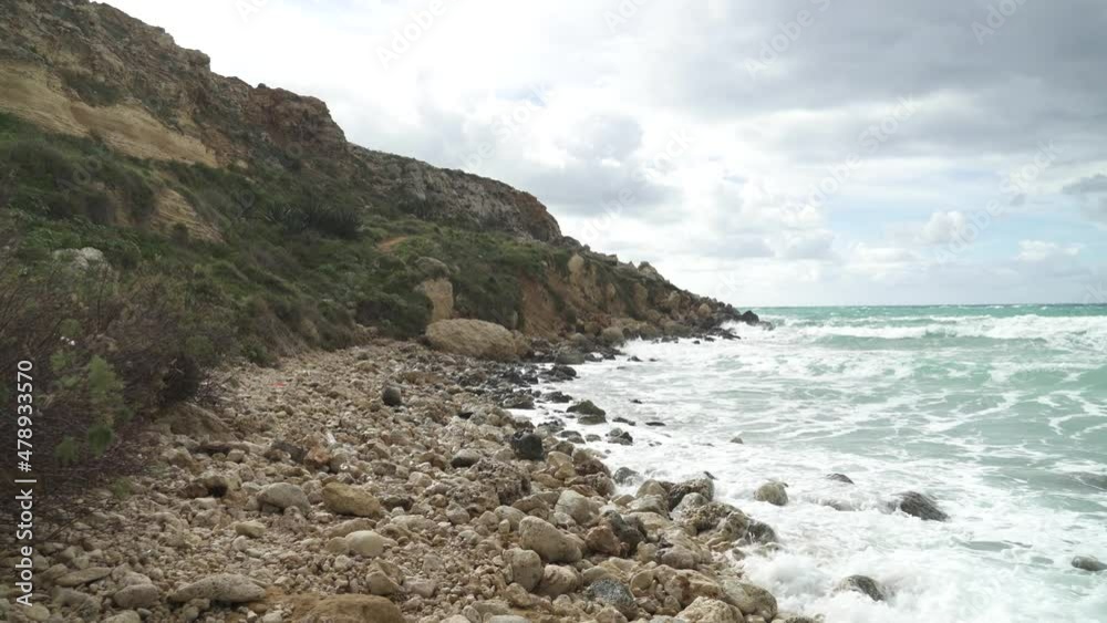 Walking on Rocks near Golden Bay Beach in Winter Time in Malta on a Sunny Windy Day Walking on Rocks near Golden Bay Beach in Winter Time in Malta on a Sunny Windy Day
