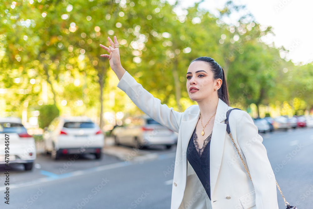 young woman in white jacket demanding a taxicab young woman in white jacket demanding a taxicab
