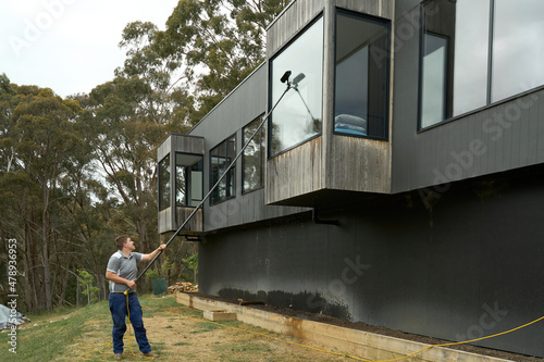 Window cleaner using long extender pole photo