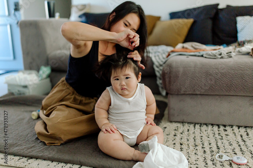 Mom is putting Asian baby's hair inept tail  photo