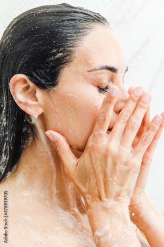 Woman taking a shower with soap photo