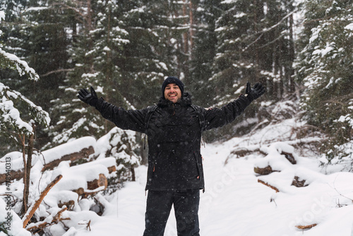 happy man during a snowfall in the middle of the forest © FranTc