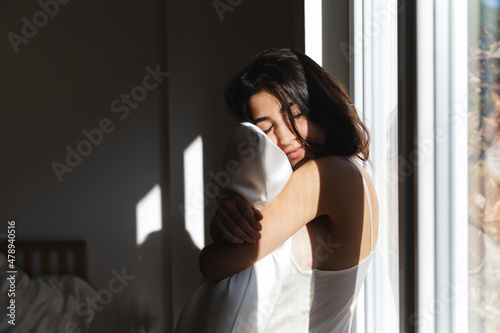 Serene woman hugging the pillow photo