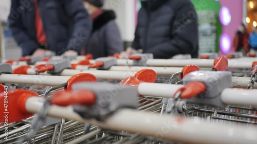 Wallpaper Mural DOF: Shoppers walk into the mall amid many grocery shopping carts. Slow motion Torontodigital.ca