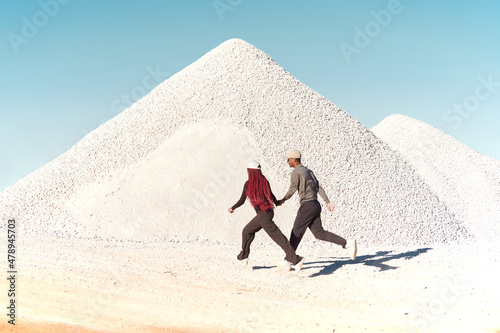 Couple running next to a white rocks mountain
