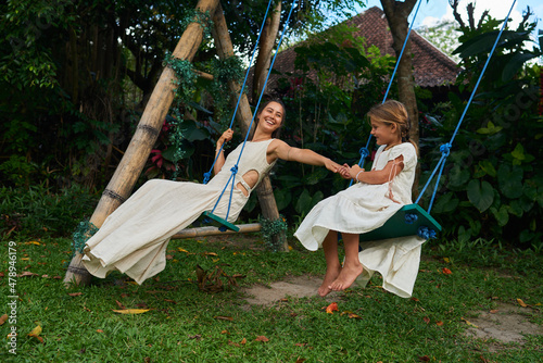 Mother with daughter on the swing photo