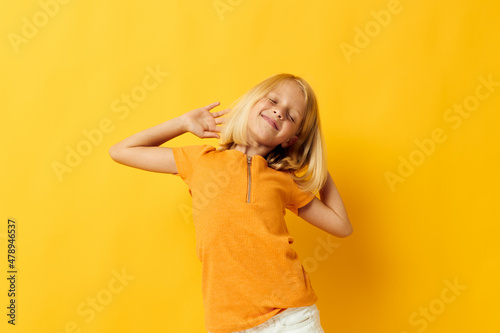 beautiful little girl in a yellow t-shirt smile posing studio childhood lifestyle unaltered