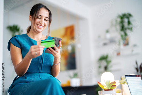 Cheerful woman making online purchases photo