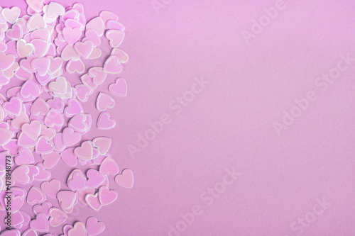 Valentines day composition. Sparkle confetti hearts on purple background. Top view, flat lay, copy space