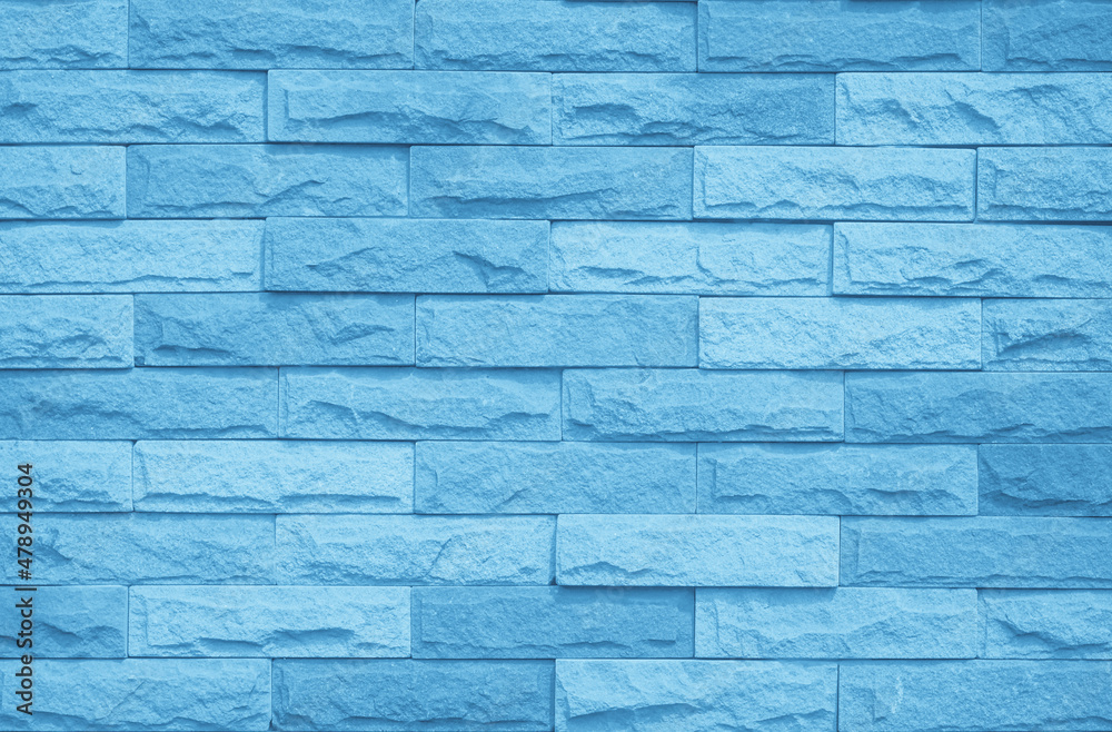 Obraz premium Brick wall painted with blue dark paint pastel calm tone texture background. Brickwork and stonework flooring interior rock old pattern clean concrete grid uneven bricks design stack backdrop.