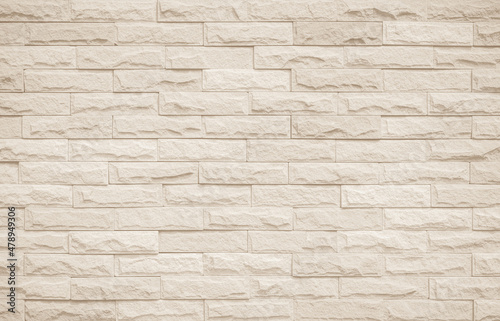 Cream and white brick wall texture background. Brickwork and stonework flooring interior rock old pattern clean concrete grid uneven bricks office design. Background of old vintage brick wall backdrop