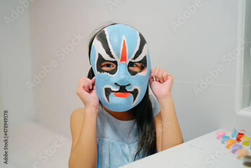 Asian child with a painting opera mask photo