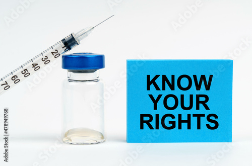 On the table is a syringe, an injection and a blue sign with the inscription - Know Your Rights