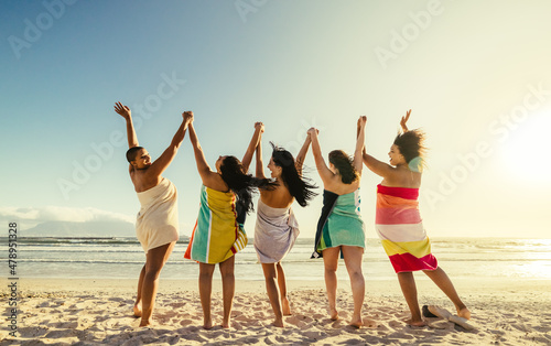Young women cheering happily at the beach