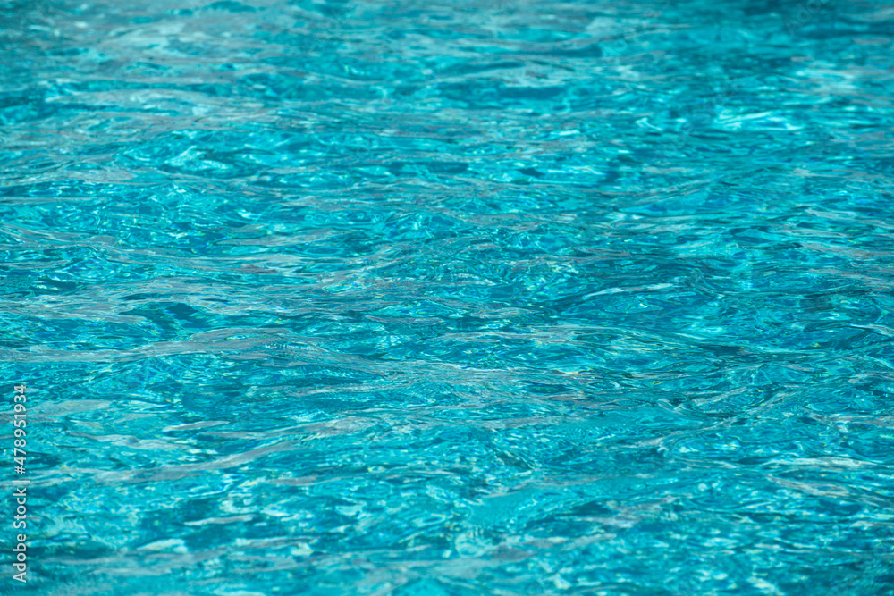 Background of blue water in swimming pool with sun reflection, ripple water wave in pool. Clear water background. Background of blue water in swimming pool with sun reflection, ripple water wave in pool. Clear water background.