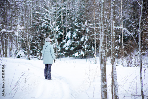 young woman in winter forest. Walking in the wild. Observation of nature in the winter season. Travel concept