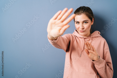 Young woman giving a halt gesture or warding off something photo