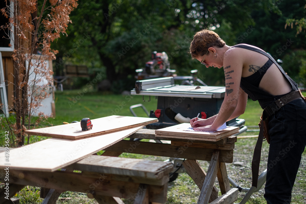 A female carpenter is working on building her project outdoors