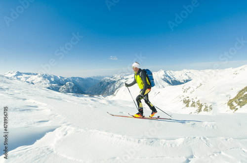 A ski mountaineer climbs with sealskins under his skis