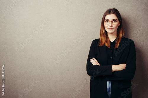 Slika na platnu Solemn confident young woman with folded arms staring at camera