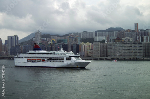 Cruiseship cruise ship liner in port of Hongkong Hong Kong, China with Kai Tak cruise terminal and city skyline	 photo