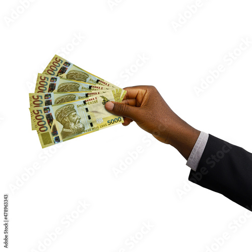 Black hand with suit holding 3D rendered 5000 Albanian lek notes isolated on white background