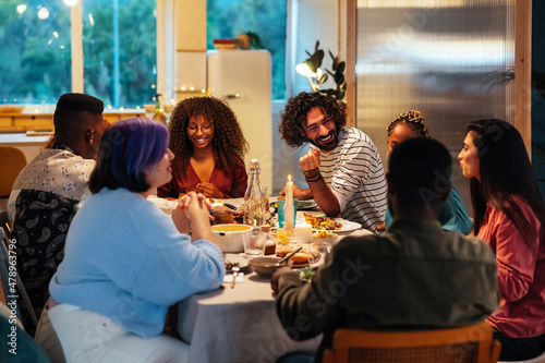 Multiracial friends gathering around table