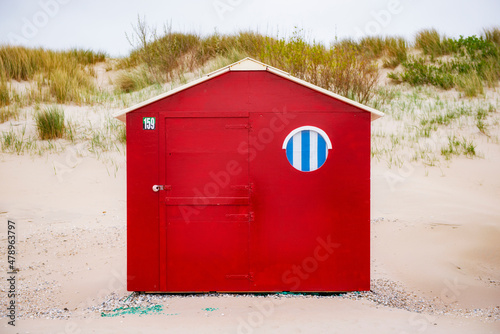 Red beachhouse with window on the beach. photo